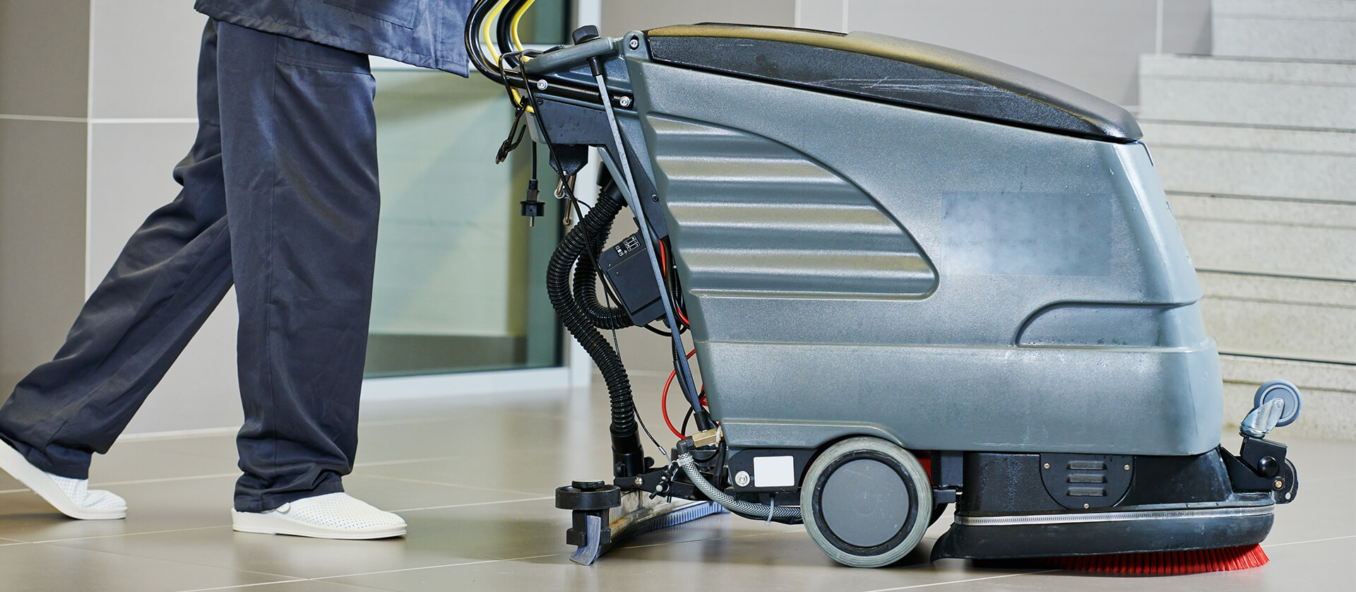 Photo of commercial floor cleaner and operator.