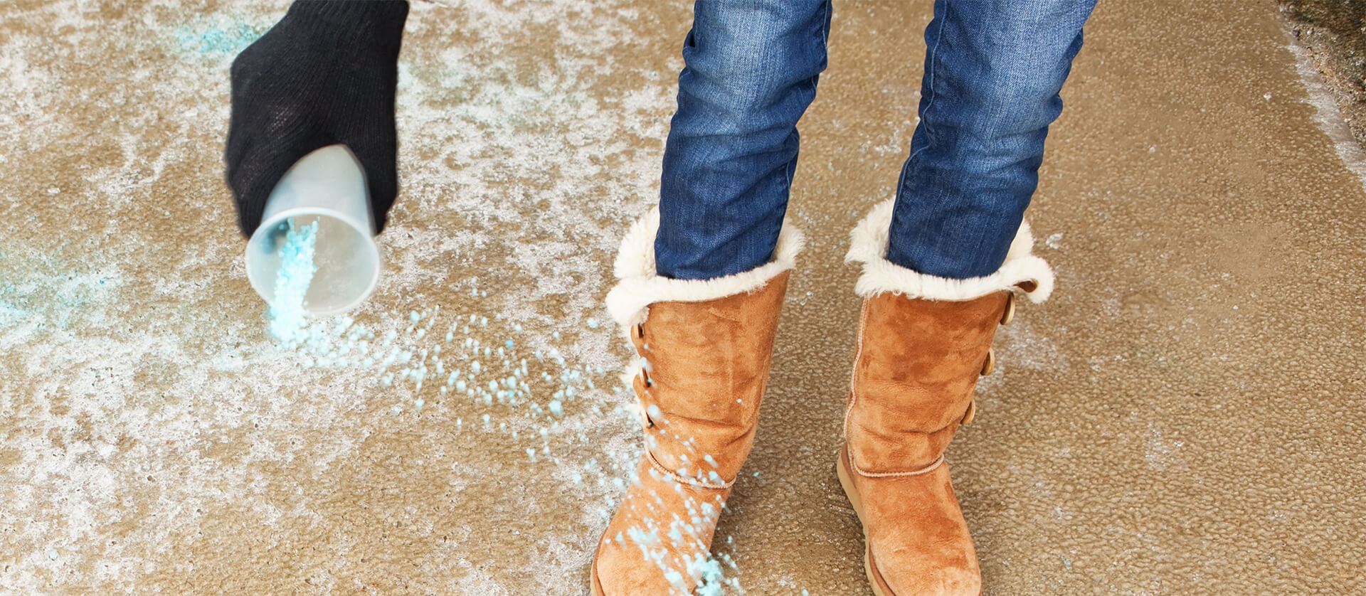 Photo of woman spreading de-icer on concrete.